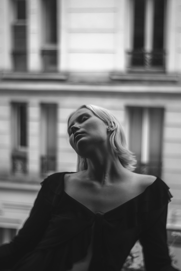Portrait en noir et blanc avec effet de mouvement devant une façade parisienne — photographie de Claude Quéré