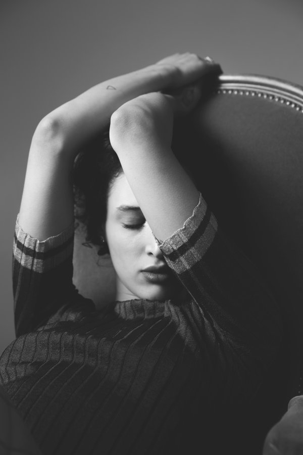 Portrait de mode en studio, la main posée sur le visage, haut à motifs sombre — photographie de Claude Quéré