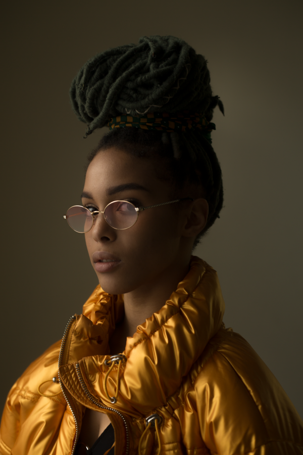 Portrait en haut doré, cheveux tressés et lunettes — photographie de Claude Quéré