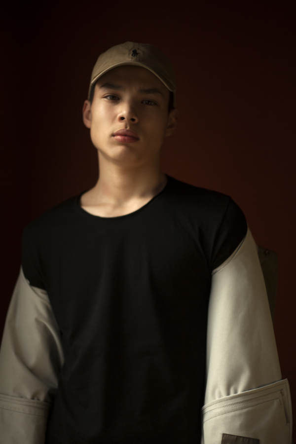 Portrait masculin en casquette, fond orangé — photographie de Claude Quéré