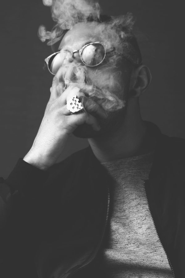 Portrait masculin fumant, lunettes relevées sur le front — photographie de Claude Quéré